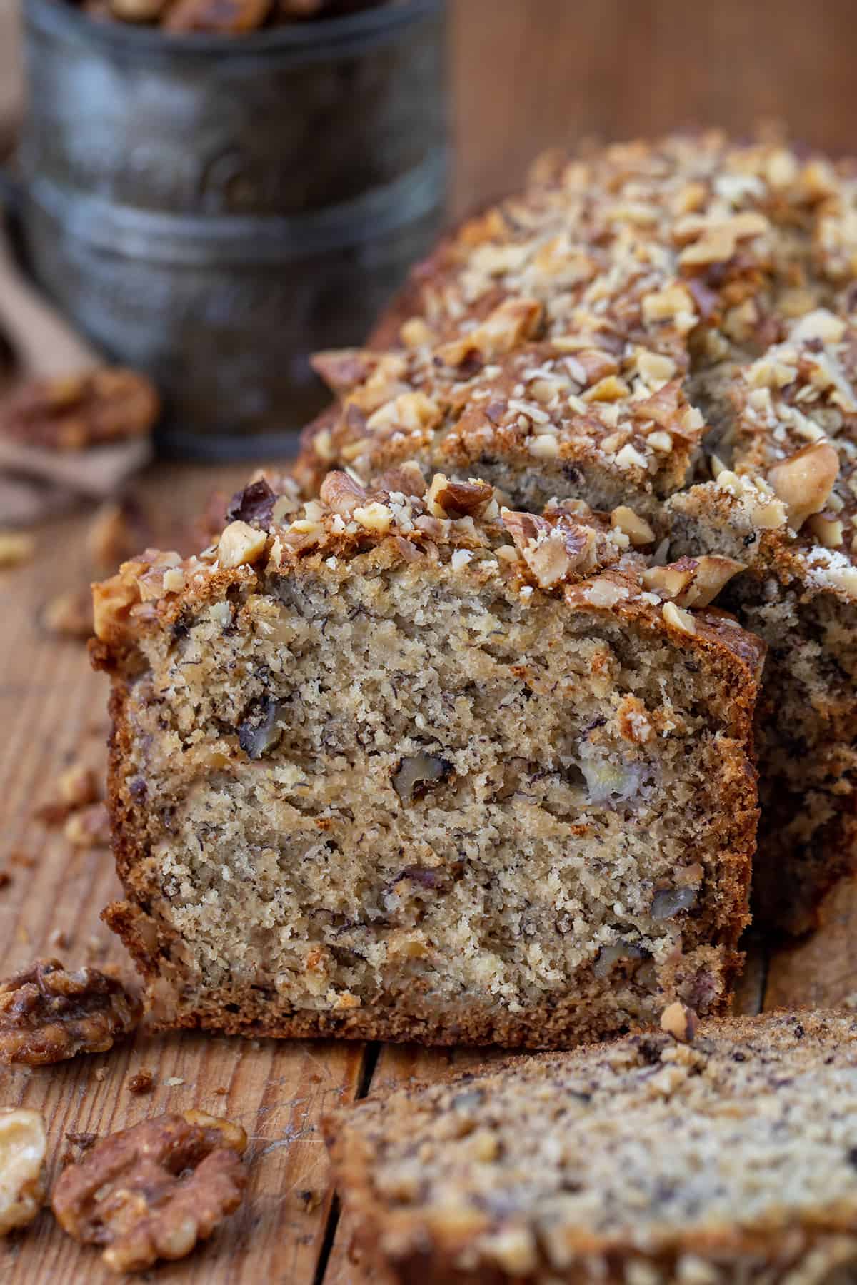 Cut Into Brown Butter Banana Nut Bread With Pieces Fallen and Focus on Piece still Near the Loaf.