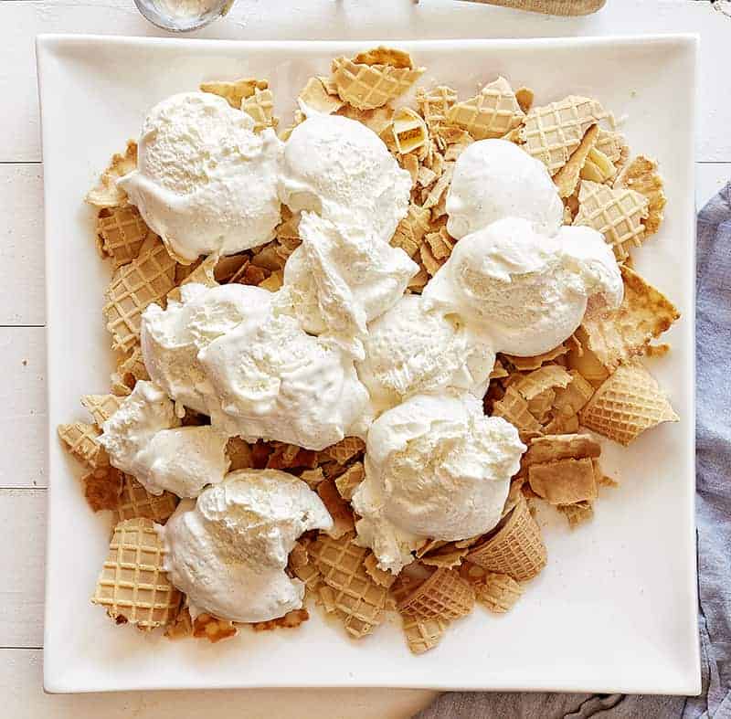 Waffle cone pieces topped with vanilla ice cream for Banana Split Nachos