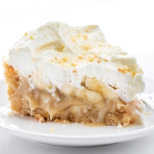 Piece of Banoffee Pie on a White Plate on a White Background.