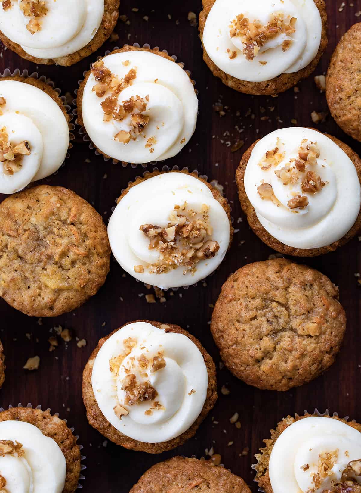 Looking down over Carrot Cake Cupcake Some with Cream Cheese Frosting and Candied Walnuts and Some Without.