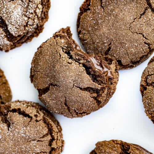 Chocolate Sandwich Cookies on a White Counter with One Bite Taken Out Showing Inside.