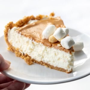 Hand Holding White Plate with Fluffernutter Pie on It.