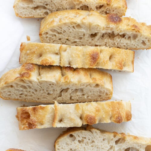 Cut up Pieces of Sourdough Focaccia on a White Cutting Board.