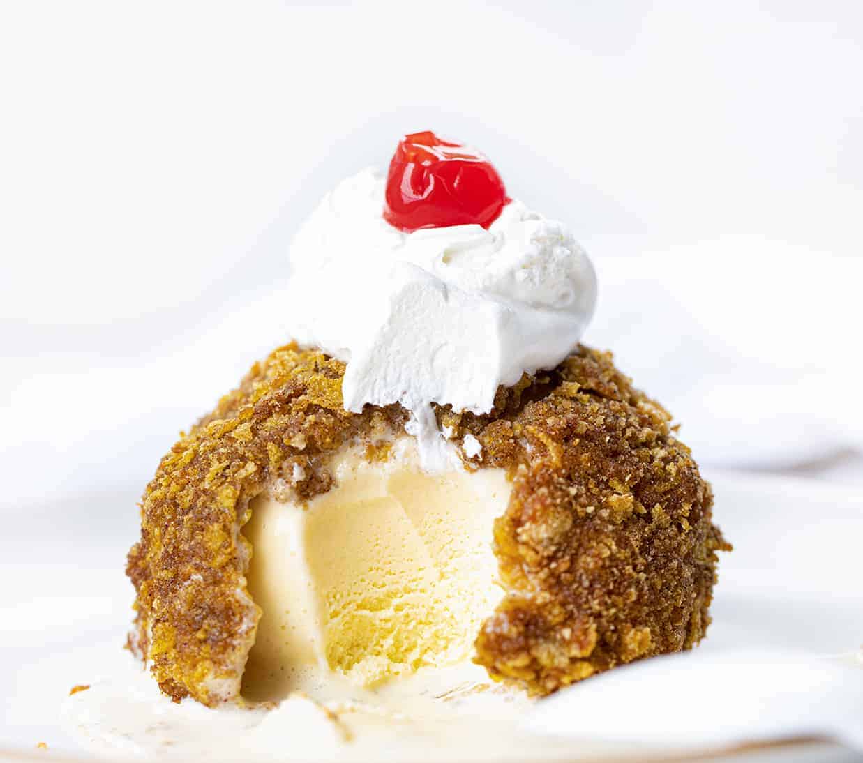 Fried Ice Cream with Bite Take out on a White Plate.
