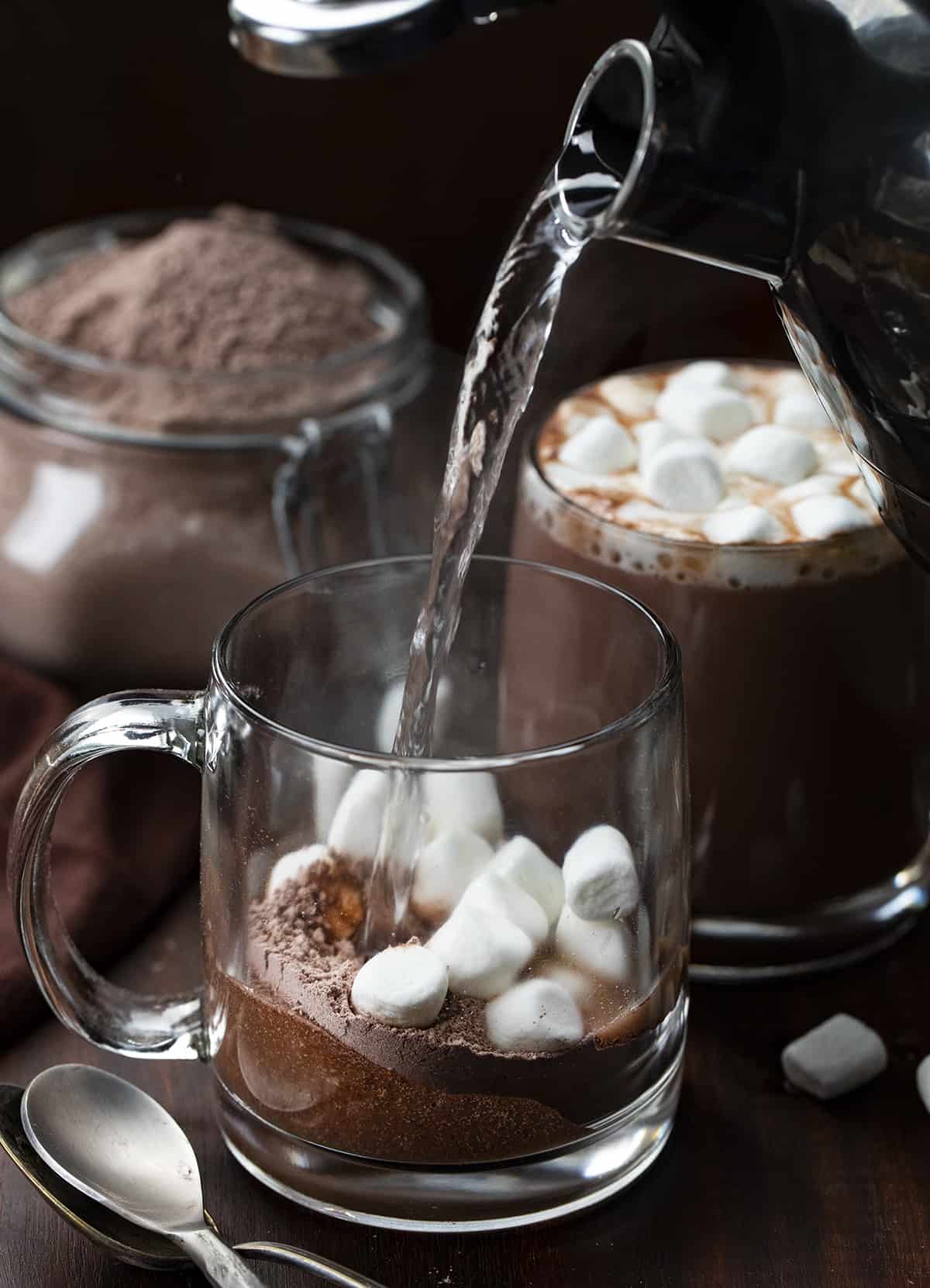 Pouring hot water to a glass with homemade hot cocoa mix and mini marshmallows in it. 