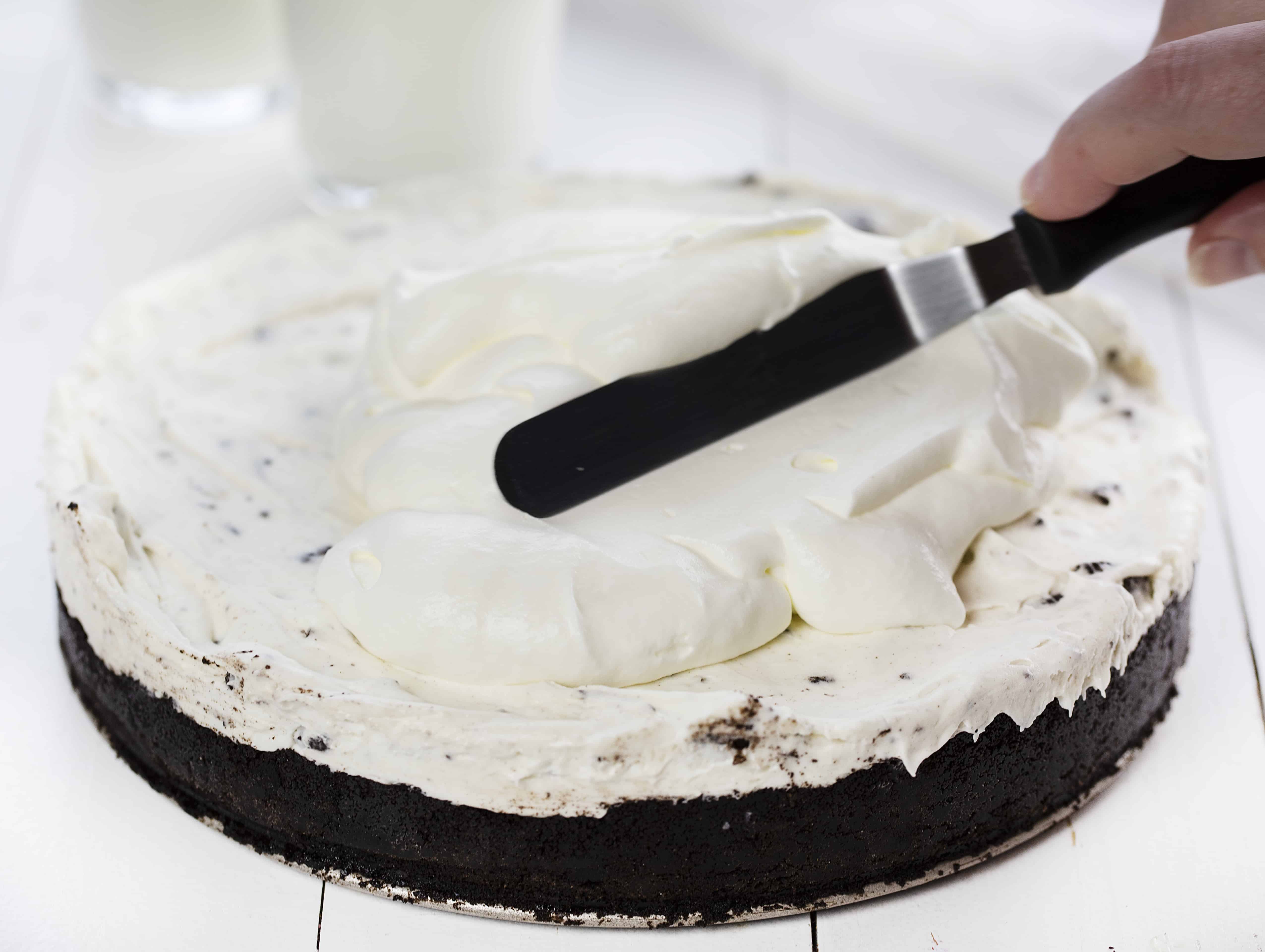 No Bake Oreo Cheesecake with Homemade Whipped Topping Being Spread on Top