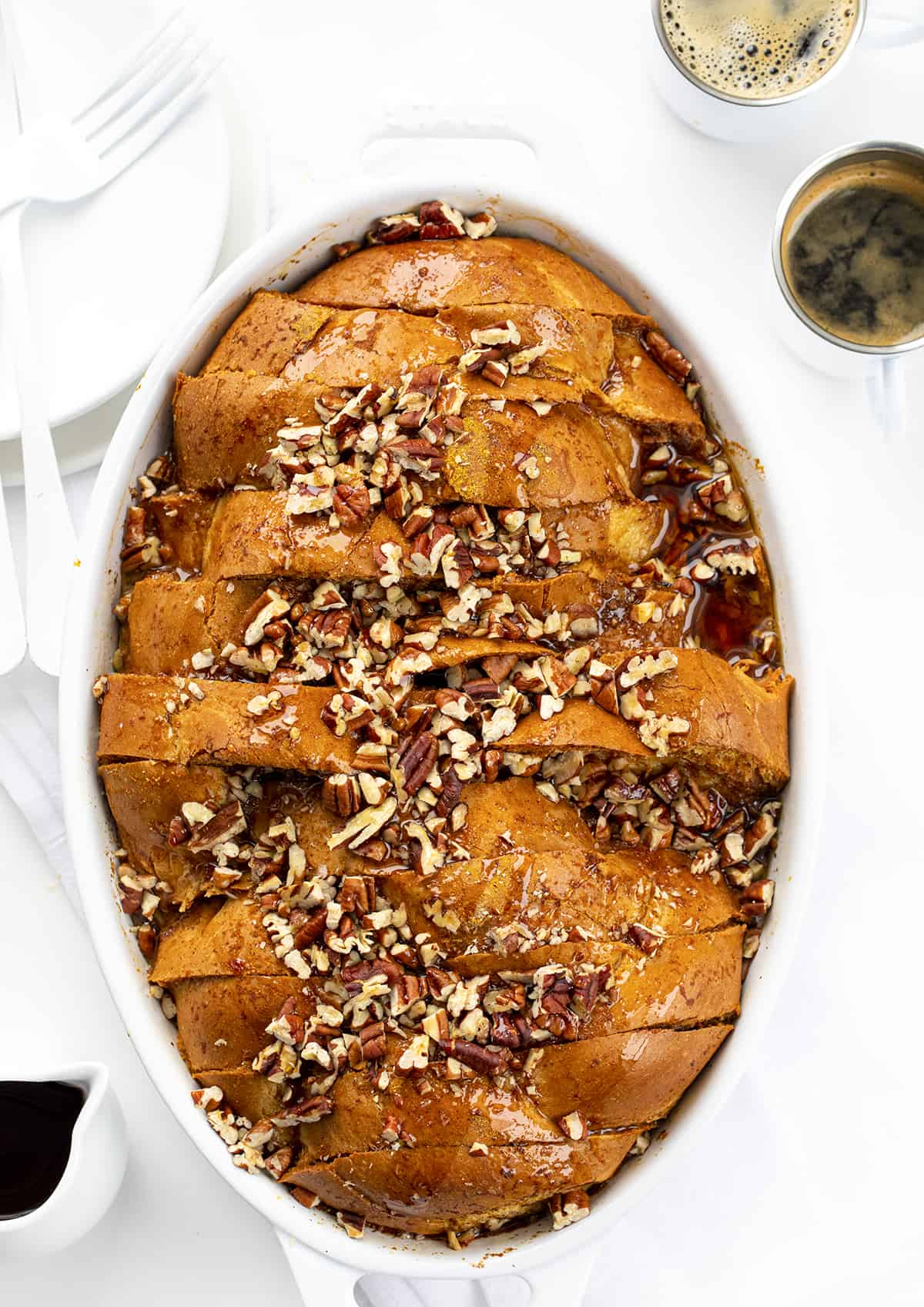 Pumpkin French Toast Casserole in a White Casserole Dish on a Counter with Espresso.