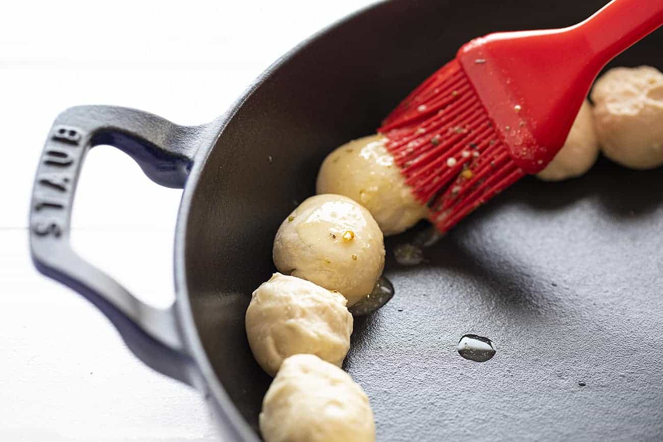 Bread Being Buttered and Seasoned for Skillet Pizza Dip