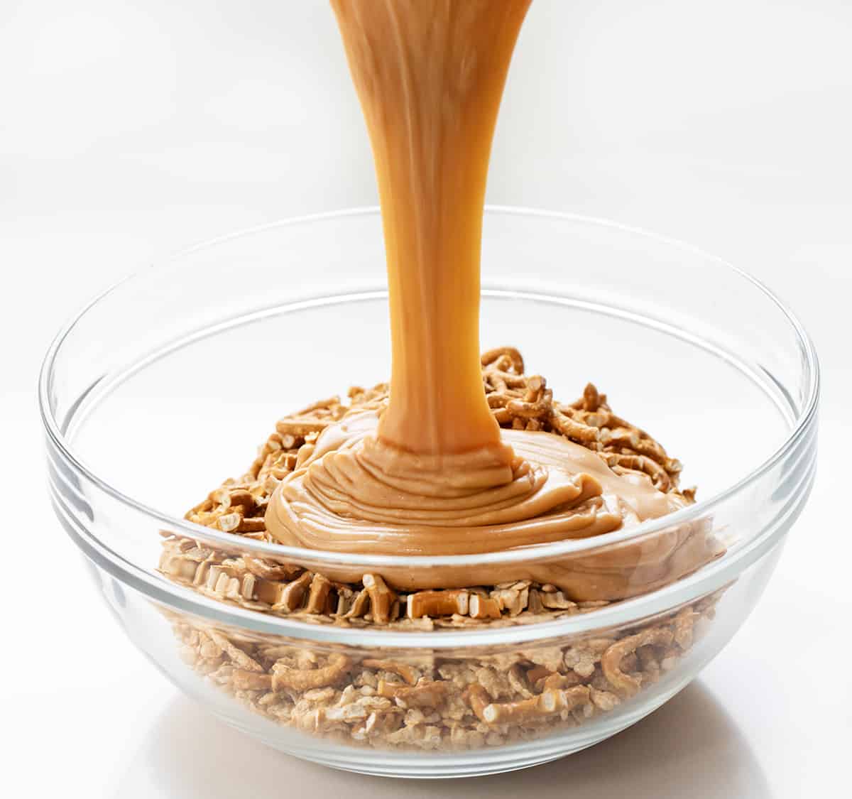 Adding Caramel Mixture to Pretzel Scotcheroos Bowl of Ingredients.