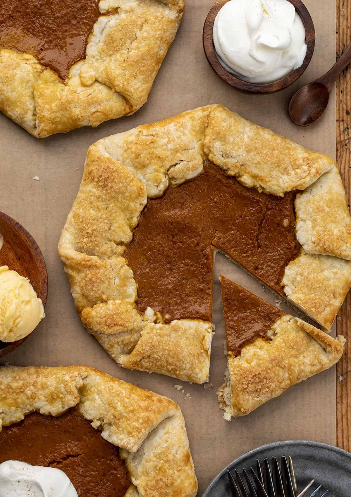 Homemade Pumpkin Galettes on a Cutting Board Uncut and Next to Whipping Cream and Ice Cream. Dessert, Thanksgiving, Pumpkin Pie Galette, Easy Pumpkin Dessert, How to Make Pumpkin Galette, Holiday Desserts, Easy Dessert, Pie Crust, Galette, i am baker, iambaker