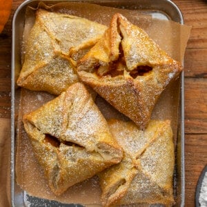 Pumpkin Cream Cheese Danish in a Tray Dusted with Confectioners Sugar. Breakfast, Snack, Pumpkin Danish, Puff Pastry, Pumpkin Puff Pastry, Pumpkin Cream Cheese Puff Pastry, Breakfast Danish, Dessert, Baking, Holiday Recipes, Thanksgiving Breakfast, Christmas Breakfast, i am baker, iambaker