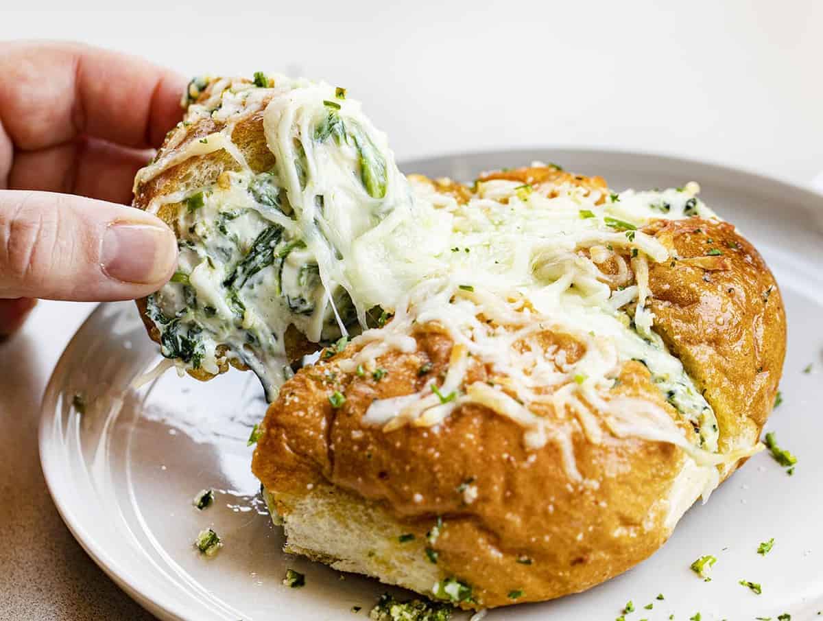 Hand Pulling Apart Spinach Artichoke Bread