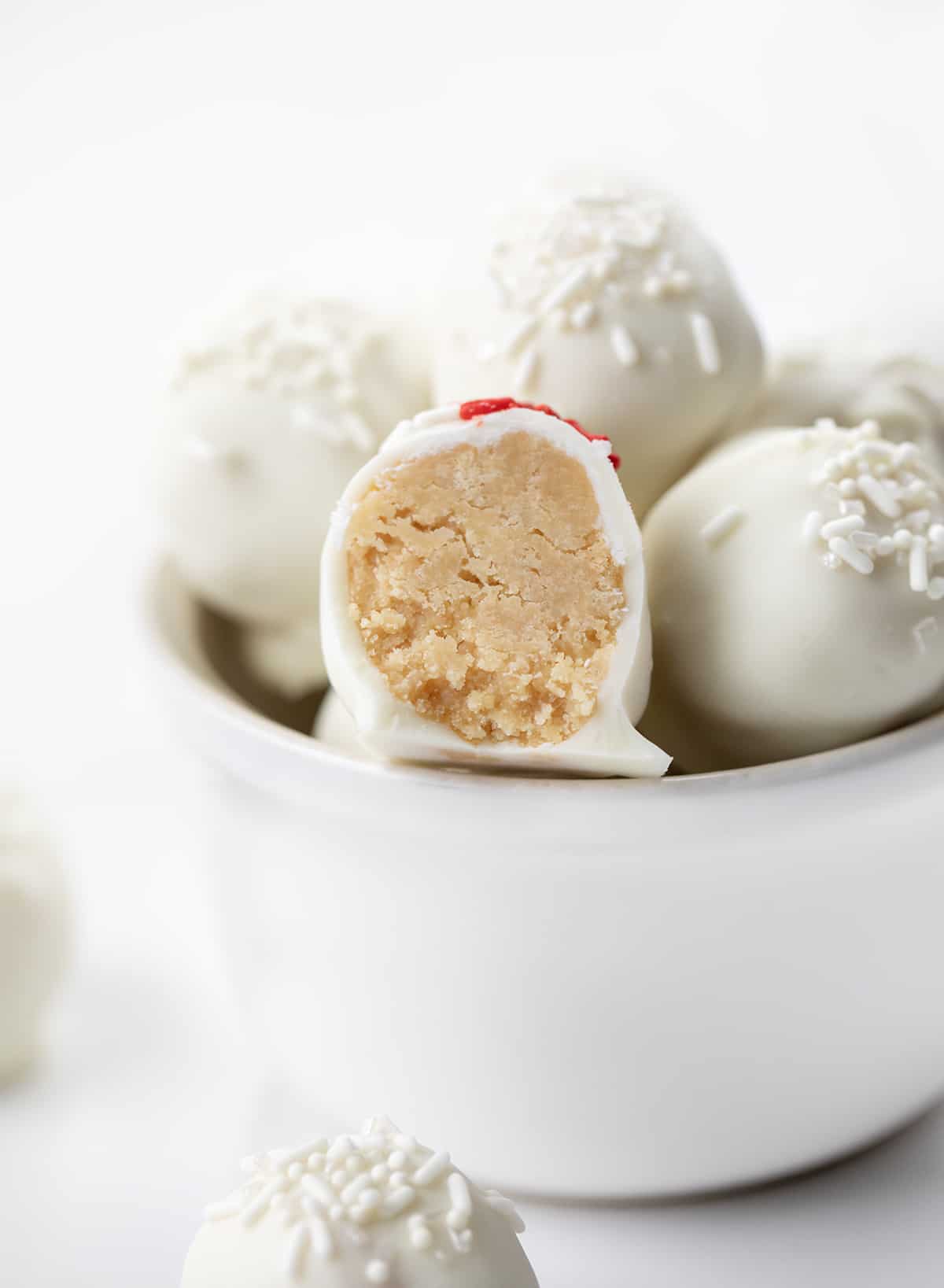 One cut in half Sugar Cookie Truffles on a Stack But Showing the Inside Texture.