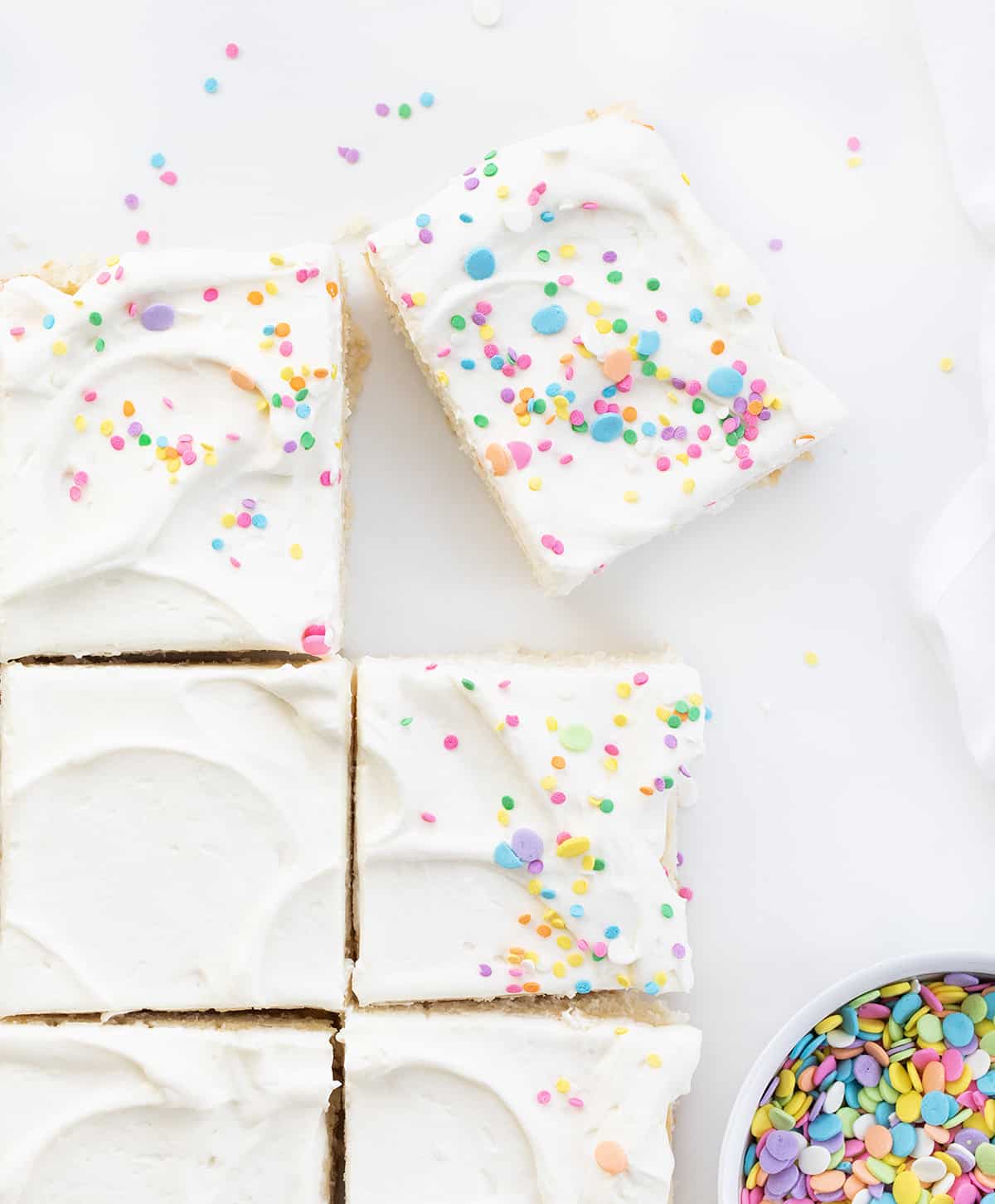 Pieces of Vanilla-Delight Cake or White Cake on a Counter with Pastel Colored Sprinkles.