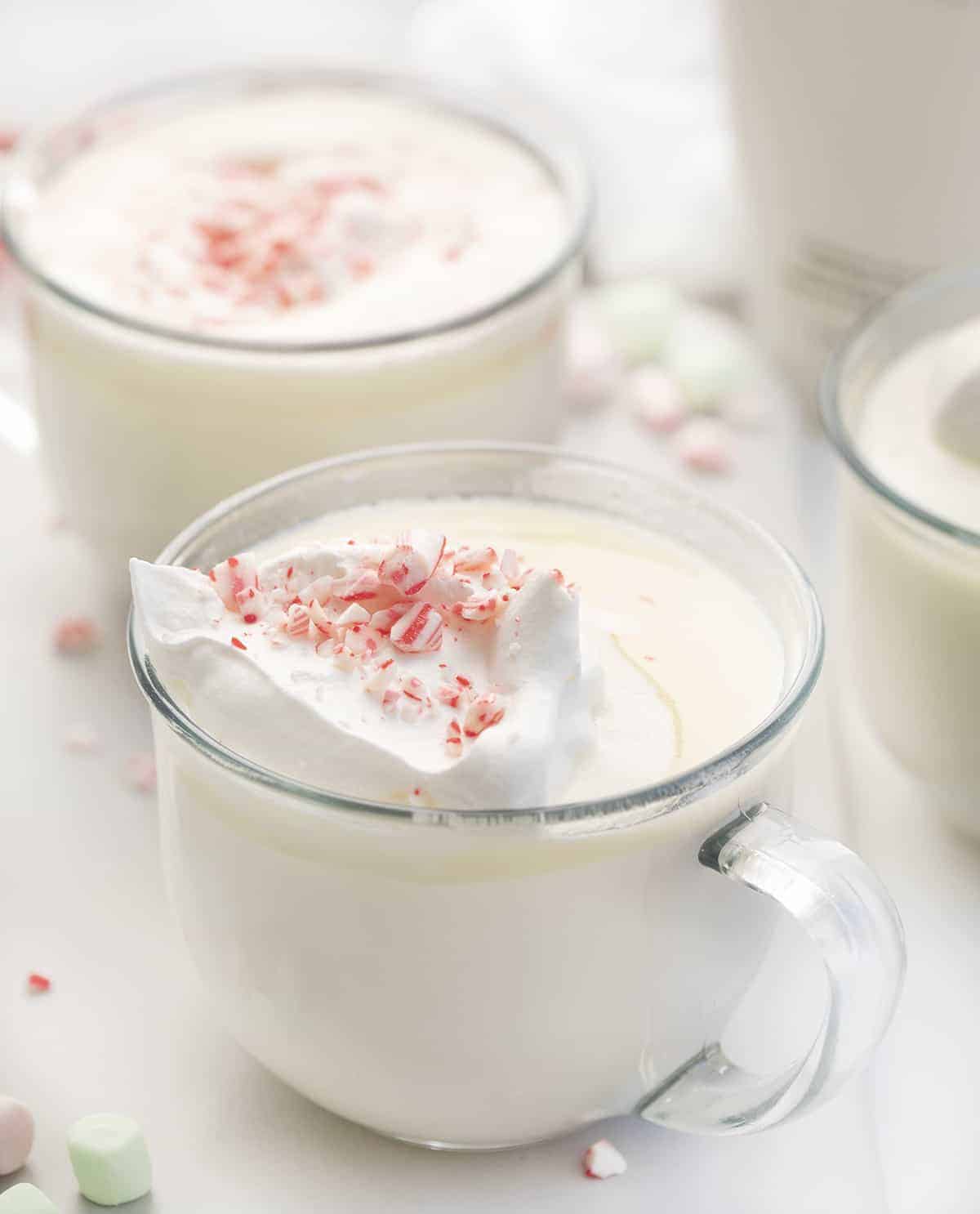 Glassed of White Chocolate Hot Cocoa with Whipped Cream and Candycanes